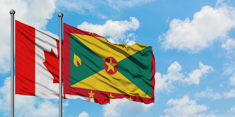 Canada and Grenada flag waving in the wind against white cloudy blue sky together. Diplomacy concept, international relations.