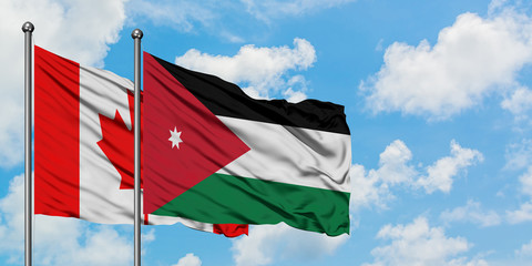 Canada and Jordan flag waving in the wind against white cloudy blue sky together. Diplomacy...