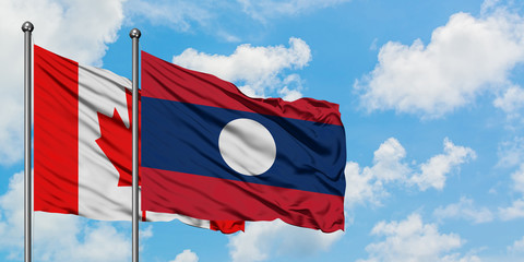 Canada and Laos flag waving in the wind against white cloudy blue sky together. Diplomacy concept, international relations.