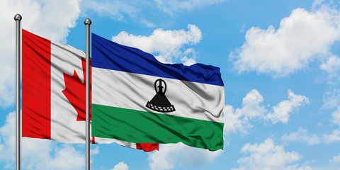 Canada and Lesotho flag waving in the wind against white cloudy blue sky together. Diplomacy concept, international relations.
