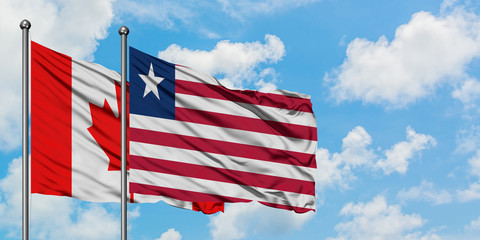 Canada and Liberia flag waving in the wind against white cloudy blue sky together. Diplomacy concept, international relations.