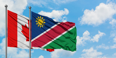 Canada and Namibia flag waving in the wind against white cloudy blue sky together. Diplomacy concept, international relations.