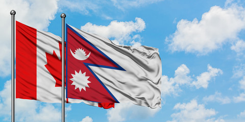 Canada and Nepal flag waving in the wind against white cloudy blue sky together. Diplomacy concept, international relations.