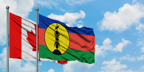 Canada and New Caledonia flag waving in the wind against white cloudy blue sky together. Diplomacy concept, international relations.