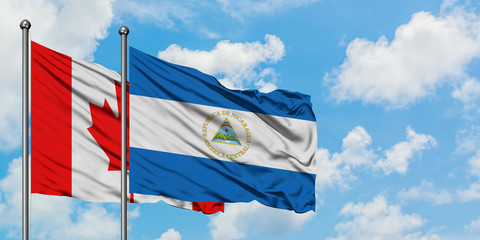 Canada and Nicaragua flag waving in the wind against white cloudy blue sky together. Diplomacy concept, international relations.