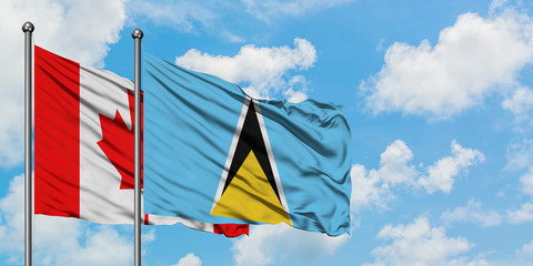 Canada and Saint Lucia flag waving in the wind against white cloudy blue sky together. Diplomacy concept, international relations.