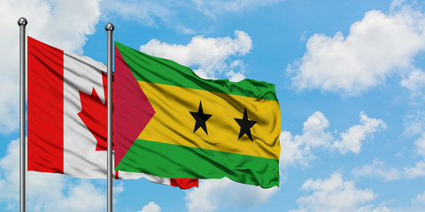 Canada and Sao Tome And Principe flag waving in the wind against white cloudy blue sky together. Diplomacy concept, international relations.