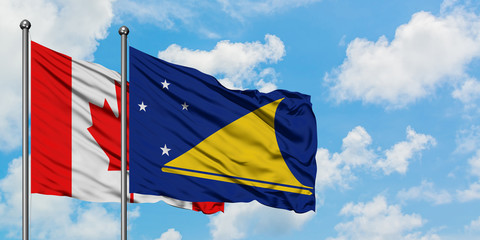 Canada and Tokelau flag waving in the wind against white cloudy blue sky together. Diplomacy concept, international relations.