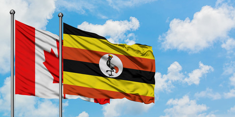 Canada and Uganda flag waving in the wind against white cloudy blue sky together. Diplomacy concept, international relations.