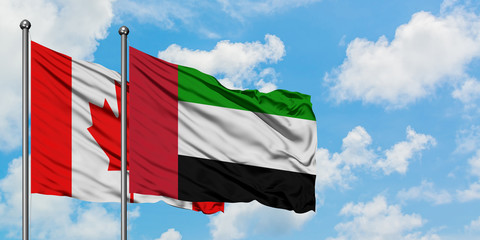 Fototapeta na wymiar Canada and United Arab Emirates flag waving in the wind against white cloudy blue sky together. Diplomacy concept, international relations.