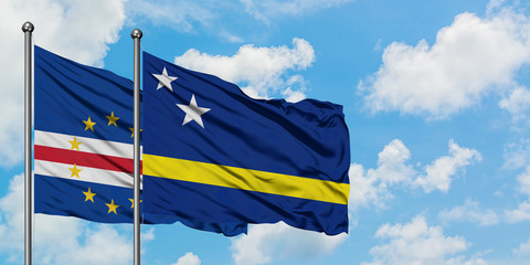 Cape Verde and Curacao flag waving in the wind against white cloudy blue sky together. Diplomacy concept, international relations.