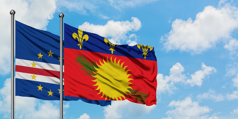 Cape Verde and Guadeloupe flag waving in the wind against white cloudy blue sky together. Diplomacy concept, international relations.