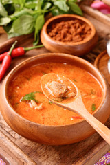 Thai red chicken curry in wooden bowl