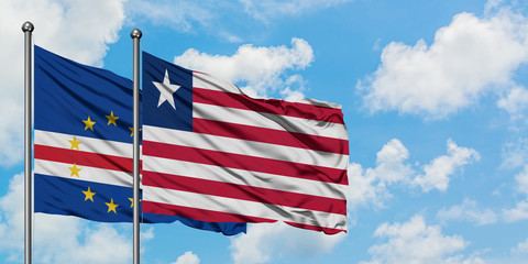 Cape Verde and Liberia flag waving in the wind against white cloudy blue sky together. Diplomacy concept, international relations.
