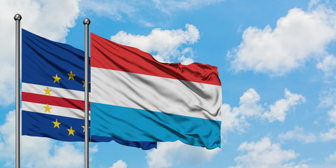 Cape Verde and Luxembourg flag waving in the wind against white cloudy blue sky together. Diplomacy concept, international relations.