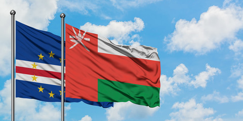 Cape Verde and Oman flag waving in the wind against white cloudy blue sky together. Diplomacy concept, international relations.