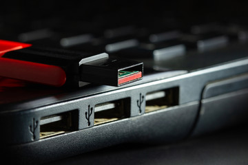 Flash drive in USB port of computer notebook in darkness. Concept of technological advances in...