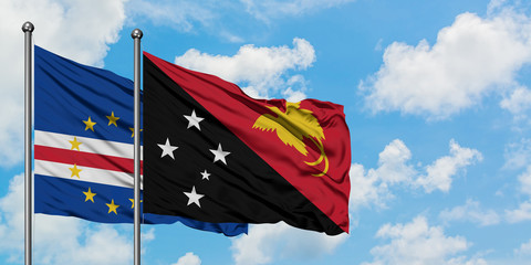 Cape Verde and Papua New Guinea flag waving in the wind against white cloudy blue sky together. Diplomacy concept, international relations.