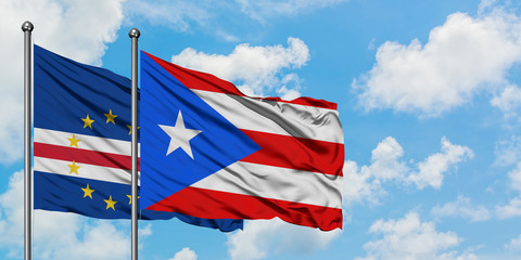 Cape Verde and Puerto Rico flag waving in the wind against white cloudy blue sky together. Diplomacy concept, international relations.