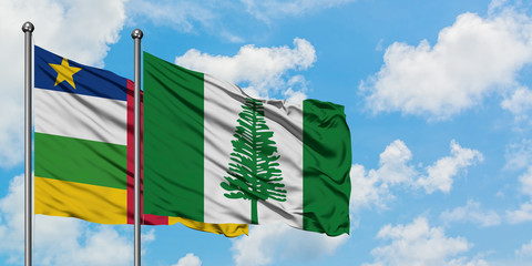 Central African Republic and Norfolk Island flag waving in the wind against white cloudy blue sky together. Diplomacy concept, international relations.