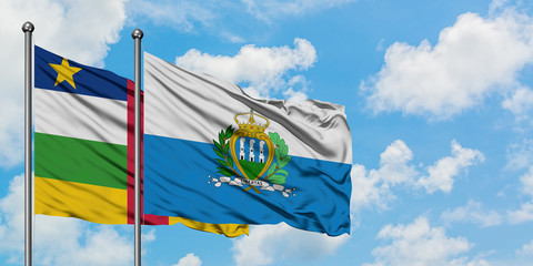 Central African Republic and San Marino flag waving in the wind against white cloudy blue sky together. Diplomacy concept, international relations.