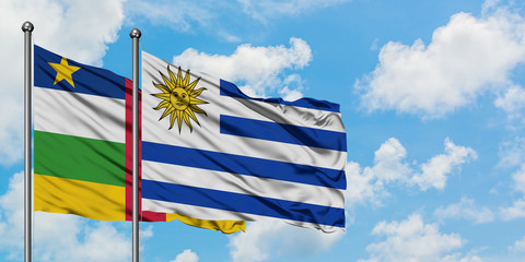 Central African Republic and Uruguay flag waving in the wind against white cloudy blue sky together. Diplomacy concept, international relations.