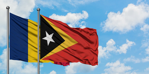 Chad and East Timor flag waving in the wind against white cloudy blue sky together. Diplomacy concept, international relations.