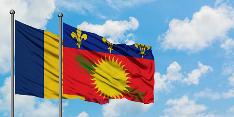 Chad and Guadeloupe flag waving in the wind against white cloudy blue sky together. Diplomacy concept, international relations.