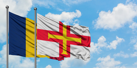 Chad and Guernsey flag waving in the wind against white cloudy blue sky together. Diplomacy concept, international relations.