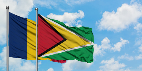 Chad and Guyana flag waving in the wind against white cloudy blue sky together. Diplomacy concept, international relations.