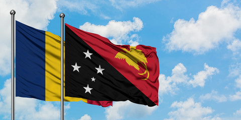 Chad and Papua New Guinea flag waving in the wind against white cloudy blue sky together. Diplomacy concept, international relations.