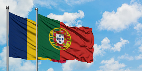 Chad and Portugal flag waving in the wind against white cloudy blue sky together. Diplomacy concept, international relations.