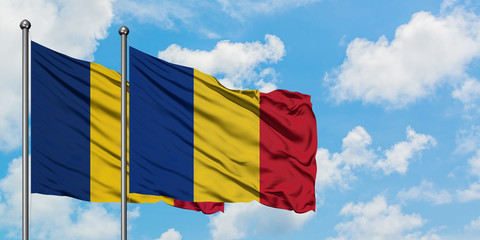 Chad and Romania flag waving in the wind against white cloudy blue sky together. Diplomacy concept,...