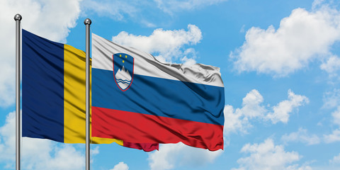 Chad and Slovenia flag waving in the wind against white cloudy blue sky together. Diplomacy concept, international relations.