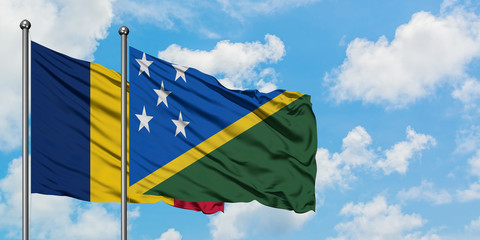 Chad and Solomon Islands flag waving in the wind against white cloudy blue sky together. Diplomacy concept, international relations.