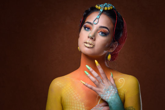 Retrato de mujer hermosa y sexy de aspecto de odalisca con maquillaje art&iacute;stico en cuerpo y manos