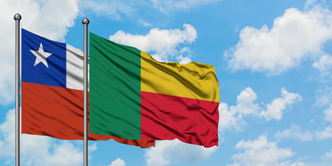 Chile and Benin flag waving in the wind against white cloudy blue sky together. Diplomacy concept, international relations.