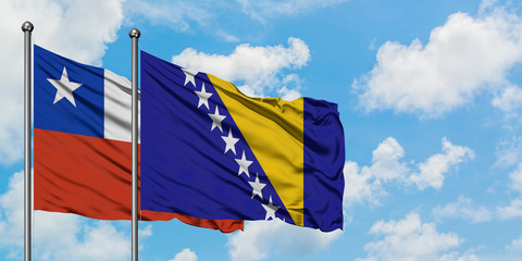 Chile and Bosnia Herzegovina flag waving in the wind against white cloudy blue sky together. Diplomacy concept, international relations.