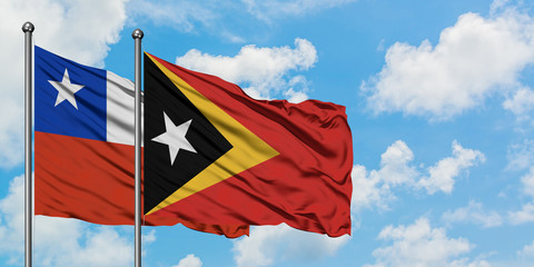 Chile and East Timor flag waving in the wind against white cloudy blue sky together. Diplomacy concept, international relations.