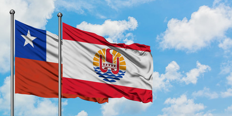Chile and French Polynesia flag waving in the wind against white cloudy blue sky together. Diplomacy concept, international relations.