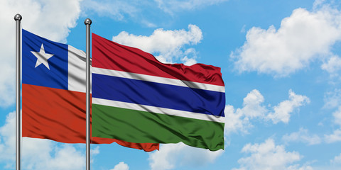 Chile and Gambia flag waving in the wind against white cloudy blue sky together. Diplomacy concept, international relations.