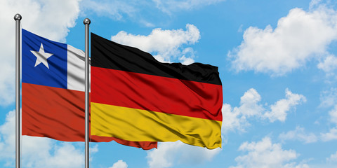 Chile and Germany flag waving in the wind against white cloudy blue sky together. Diplomacy concept, international relations.