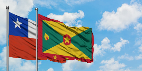 Chile and Grenada flag waving in the wind against white cloudy blue sky together. Diplomacy concept, international relations.
