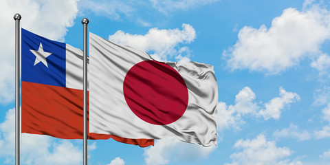 Chile and Japan flag waving in the wind against white cloudy blue sky together. Diplomacy concept, international relations.