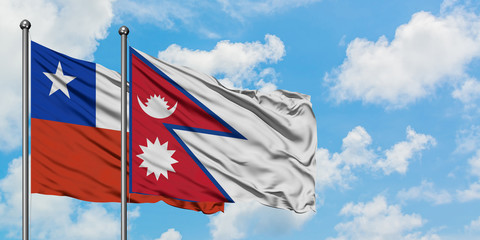 Chile and Nepal flag waving in the wind against white cloudy blue sky together. Diplomacy concept, international relations.