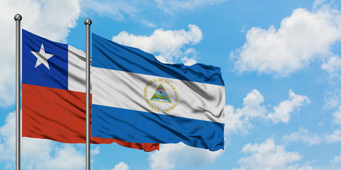Chile and Nicaragua flag waving in the wind against white cloudy blue sky together. Diplomacy concept, international relations.
