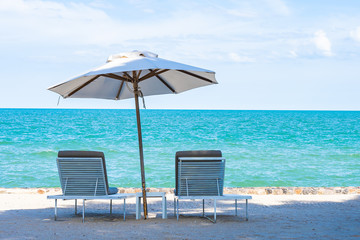 Beautiful umbrella and chair around beach sea ocean with blue sky for travel