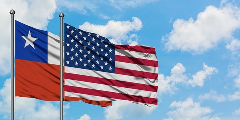 Chile and United States flag waving in the wind against white cloudy blue sky together. Diplomacy concept, international relations.
