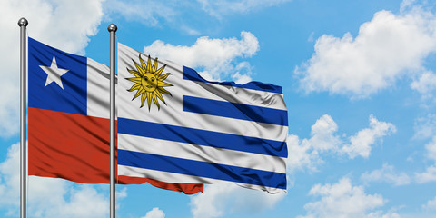 Chile and Uruguay flag waving in the wind against white cloudy blue sky together. Diplomacy concept, international relations.