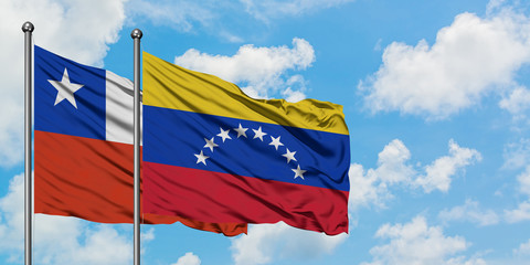 Chile and Venezuela flag waving in the wind against white cloudy blue sky together. Diplomacy concept, international relations.